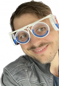 Tobias trägt die Motion Sickness Brille und grinst dabei